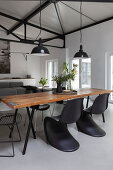 Rustic dining table and classic chairs in open-plan interior