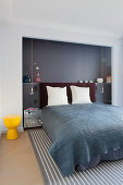 Double bed with head in grey-painted niche in bedroom
