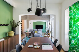 Edler Tisch aus Nussbaumholz und Sideboard im Esszimmer mit grüner Wand