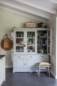 Crockery and glasses in a grey rural-style kitchen cabinet