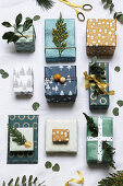 Gifts festively wrapped in shades of green and decorated with twigs