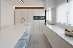 Kücheninsel in moderner weißer Küche mit Marmorboden
