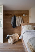 Bed in guest room with wood-clad wall