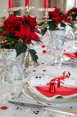 Table festively set in red and white decorated with poinsettias