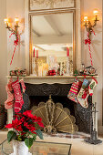 Various Christmas stockings hung on antique open fireplace