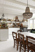 A dining table with chairs in an open-plan, shabby-chic style kitchen