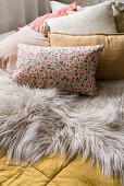 Cushions and fur blanket on double bed