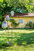 Stone sculpture in the garden, outbuilding in the background