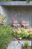 A view over a bed of hydrangeas to a terrace with loungers