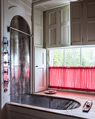 Shower in a built-in bathtub in a window alcove in a classical bathroom