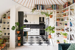 Regale mit Zimmerpflanzen und Büchern neben und über dem Durchgang zur Küche