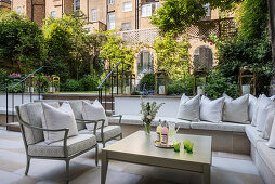 Gemauerte Sitzbank auf eleganter Terrasse im Hinterhof mit Garten