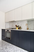 Fitted kitchen with a marble backsplash and terrazzo floor