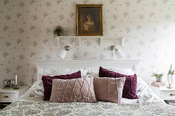 Double bed in bedroom with pretty wallpaper