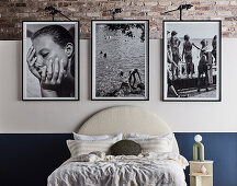 Large black and white framed photos above double bed