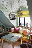 Cosy sofa with cushions, birdcages above in the attic room