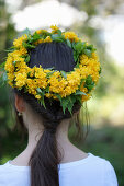 Woman wearing wreath of double Japanese marigold bush flowers on head