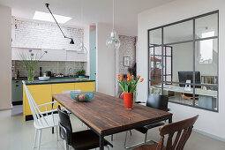 Essbereich mit verschiedenen Stühlen vor Küche, Blick ins Arbeitszimmer