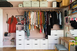 Open wardrobe against pink wall