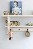 Portrait of girl and vintage ornaments on wall-mounted shelves