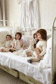 Dolls on old metal bed, suitcases and vintage-style accessories