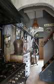 View past gas cooker in kitchen into hallway decorated with junk and vintage-style accessories