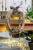 Handmade wreath of braided twine decorated with ribbon and sprigs of berries