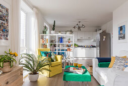 Offener Wohnraum mit Sitzbereich und Küche, offenes Regal als Raumteiler