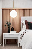 Halbhoch mit Holz verkleidete Wand im eleganten Schlafzimmer