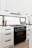 Gasherd in klassischer Küche in Weiß mit horizontalem Fenster