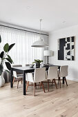 Upholstered chairs around black table in elegant dining room