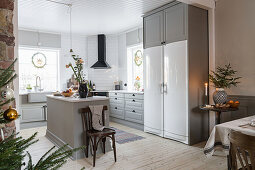 Grey, open-plan kitchen with island counter decorated for Christmas