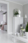 DIY-Couchtisch und weißer, halbhoher Schrank in hellem Wohnzimmer mit Tapete