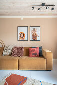 Light brown upholstered sofa, above it children's photos in the living room