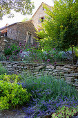 Summer garden and natural stone house on a slope
