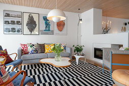 Bright seating area in an open living room with black and white striped carpet