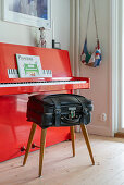 Selbstgemachter Hocker aus altem Koffer vorm roten Klavier