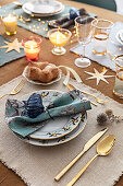 Festively set Christmas table with gold-colored cutlery
