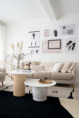 Bright living room with coffee tables, beige sofa, and modern art hanging from above
