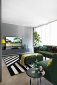 Green corner sectional sofa, side table, ottoman, wall mounted console table and TV in the living room