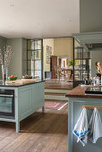 Hellgrüne, modernisierte Küche auf zwei Ebenen im Herrenhaus aus dem 18. Jahrhundert