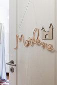 Crocheted name on door of child's bedroom