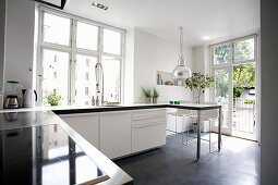 White cupboards in kitchen with concrete floor