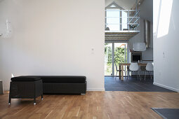 Black chaise and ottoman next to open doorway in loft apartment