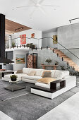 White sofa combination in high-ceilinged open-plan interior with staircase and gallery level