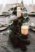 DIY garland of pine and fir branches with various cones on Christmas table