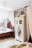 Antique wooden bed with canopy and wardrobe in a girl's room