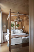 Doppelbett mit Holzgestell im Schlafzimmer mit Holzverkleidung