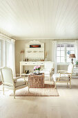 Gustavianische Sessel um Korbtruhe im Wohnzimmer in Weiß
