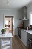 Light grey kitchen units, extractor hood and table in kitchen